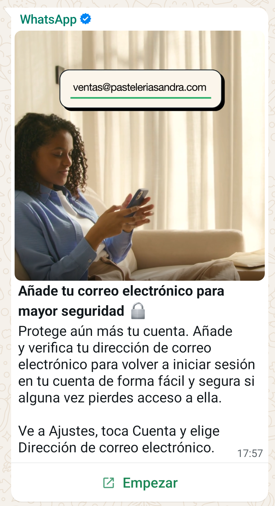 Una mujer está sentada en un sofá, mirando su teléfono móvil. La imagen está acompañada de un mensaje de WhatsApp que anima a los usuarios a añadir su correo electrónico para mejorar la seguridad de su cuenta. El texto explica cómo añadir la dirección de correo electrónico para facilitar el acceso a la cuenta en caso de pérdida de acceso. Se muestra un ejemplo de dirección de correo electrónico en la parte superior de la imagen