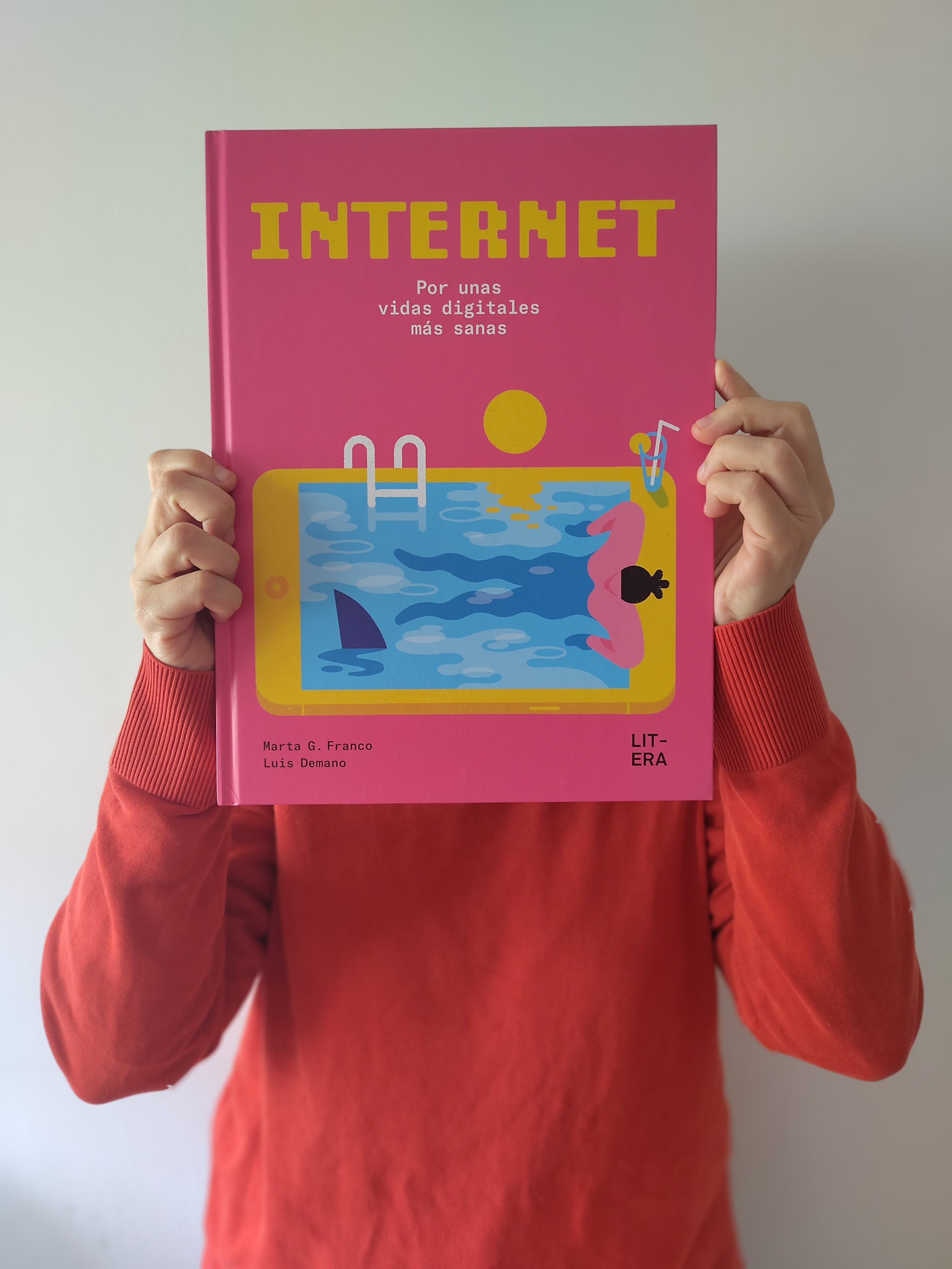 Unas manos sujetan el libro 'Internet. Por unas vidas digitales más sanas', de Marta G. Franco y Luis Demano. El libro cubre la cara de la persona que lo sujeta.